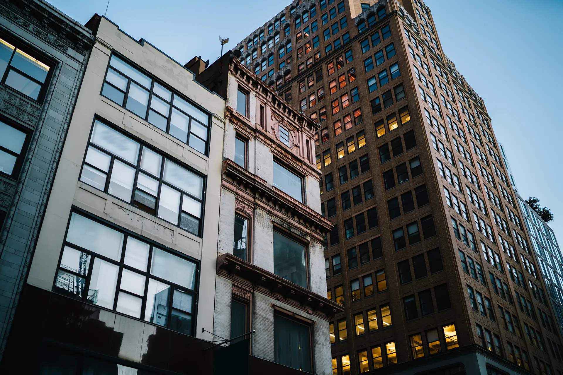 Manhattan facades at dusk with lit windows
